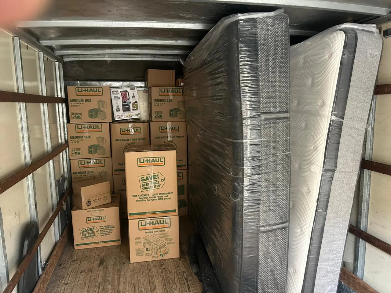 Cami&oacute;n de mudanza cargado con cajas y colch&oacute;n